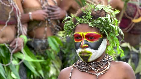 Niño-Mirando-Como-Bailarines-Saltan-En-Segundo-Plano,-Cámara-Lenta,-Papúa-Nueva-Guinea