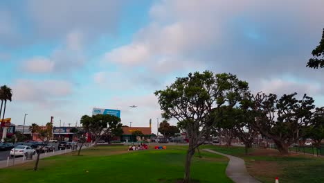 Gimbal-shot-of-United-Airlines-Embraer-ERJ-175LR-landing-at-LAX-Airport-seen-from-Airplane-Landing-View-Point-and-In-N-Out-Burger-in-Los-Angeles,-California,-USA