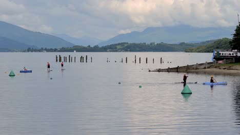 Aktiver-Lebensstil-In-Schottland,-Menschen,-Die-Auf-Paddelbrettern-Auf-Dem-Loch-Lomond-In-Schottland-Rudern