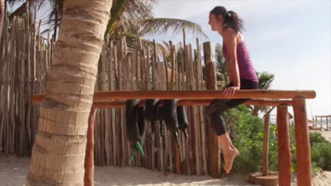 Tiro-Largo,-Mujer-Haciendo-Ejercicio-En-La-Playa-Con-Equipo-De-Madera