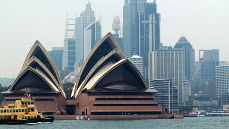Smoky-view-of-a-boat-passing-by-the-Sydney-Opera-House-with-the-skyline-in-the-background