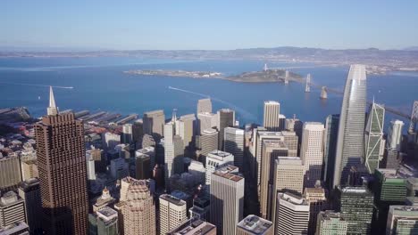 El-Dron-Aéreo-Del-Centro-De-La-Ciudad-De-San-Francisco-Gira-A-La-Derecha-Con-Vista-Al-Puente-De-La-Bahía,-La-Isla-Del-Tesoro-Y-El-Océano-Parte-Dos