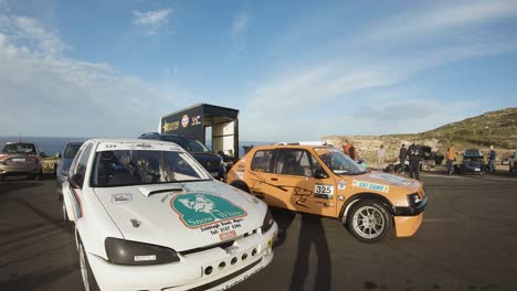 Coches-De-Carreras-Personalizados-Estacionados-Al-Final-De-La-Carretera-En-La-Exuberante-Colina-En-Imtahleb-Malta-Bajo-El-Cielo-Azul---Tiro-Panorámico-De-Gopro