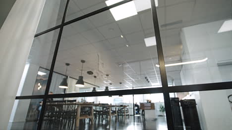 Sliding-shot-of-black-aluminium-window-frame-with-break-room-in-the-background