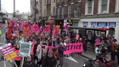 People-lead-an-Extinction-Rebellion-protest-with-a-large-bright-pink-banner-that-says-“Climate-Justice”