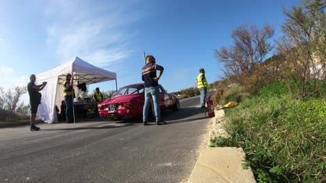 Equipos-De-Boxes-Revisando-Los-Autos-De-Carrera-Parando-En-La-Parada-En-Boxes-En-La-Colina-En-Imtahleb-Malta-En-Un-Día-Soleado---Gopro-Timelapse