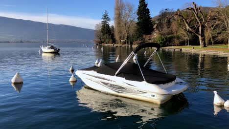 Un-Barco-Larson-En-El-Agua,-Cubierto-Y-Meciéndose-En-Las-Pequeñas-Olas-Del-Lago-Leman