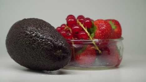 Gemischte-Früchte-In-Einem-Plattenteller-Sieht-Köstlich-Aus-Trauben-Und-Erdbeeren-In-Einer-Glasschale-Mit-Avocado-Auf-Der-Seite---Nahaufnahme