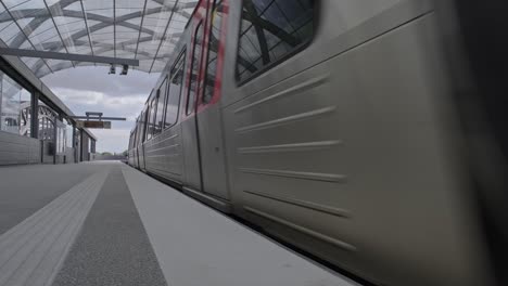 Zeitgenössischer-Zug,-Der-Sich-In-Bewegung-Setzt-Und-Den-Bahnsteig-Des-Modernen-Bahnhofs-In-Der-Stadt-Verlässt