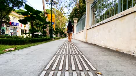 Vista-Trasera-De-Una-Mujer-De-Saigón-Caminando-Por-El-Sendero-En-Ho-Chi-Minh,-Vietnam---Tiro-De-Muñeca-En-Cámara-Lenta