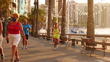 Locked-shot-of-Tourists-wearing-protective-masks-due-to-Coronavirus-in-Benidorm,-Spain