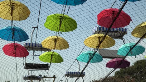 Sky-Lift-without-people-Passing-By-Above-Colorful-Umbrellas-In-Canopy-At-The-Seoul-Grand-Park,-Gyeonggi-do,-South-Korea---low-angle-shot