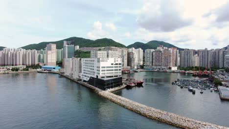 Large-Mercedes-Benz-sign-spinning-on-top-of-Hong-Kong-Mercedes-Benz-main-showroom-in-Chai-Wan-area,-Aerial-view