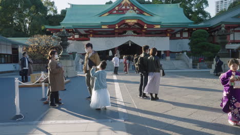 Familia-Con-Máscaras-Mientras-Visita-Su-Santuario-Durante-La-Pandemia---Tokio,-Japón---Plano-Medio,-Cámara-Lenta