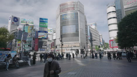 Escena-En-El-Cruce-De-Shibuya-Con-Personas-Contra-El-Paisaje-Urbano-De-Edificios-De-Gran-Altura-Durante-La-Pandemia-En-Tokio,-Japón