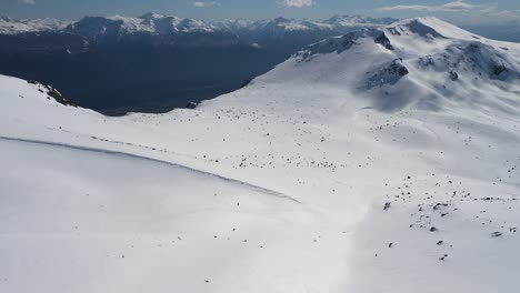 Dolly-Bajando-Sobre-El-Cerro-Piltriquitrón-Cubierto-De-Nieve,-Montañas-Al-Fondo,-El-Bolsón,-Patagonia-Argentina