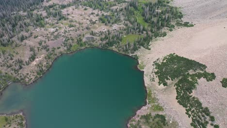 Aerial-View-of-Green-Amethyst-Lake-Water-Under-Uinta-Mountains-Peaks,-Utah-USA