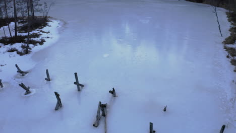 Luftdrohnenaufnahme-Einer-Alten-Eingestürzten-Brücke-In-Einem-Eisbedeckten-See