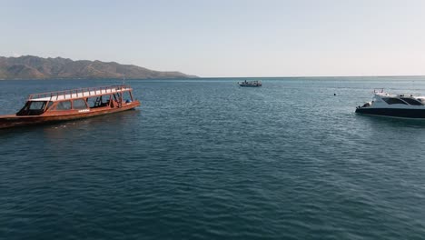 Luftüberführungsboote-Und-Yachten-Auf-Blauem-Ozeanwasser-Während-Des-Sonnigen-Tages-Und-Der-Insel-Lombok-Im-Hintergrund