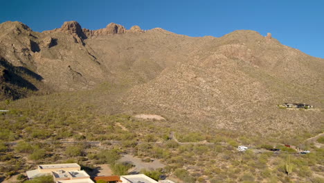Wide-drone-shot-of-mountain-range-with-an-empty-home-lot-in-foreground