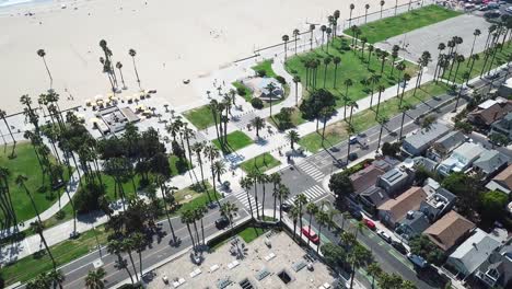Aerial-view-above-Los-Angeles-beach-landscape-tilting-to-city-neighbourhood-road