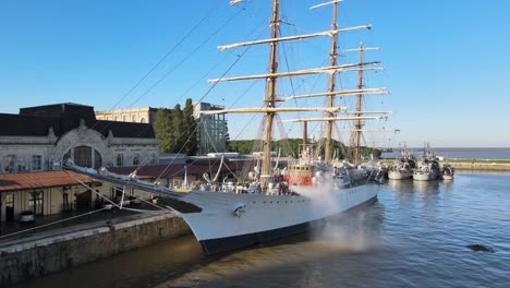 Pan-Aéreo-A-La-Izquierda-De-La-Fragata-Ara-Libertad-Atracada-Siendo-Limpiada-En-El-Muelle-De-Puerto-Madero-Durante-El-Día,-Buenos-Aires