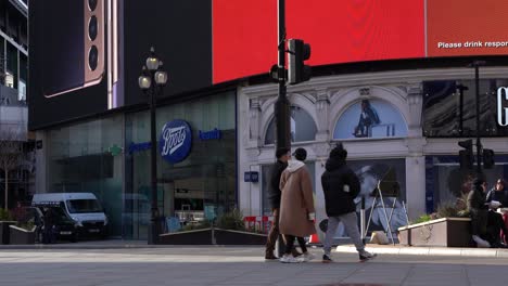 People-walking-around-Piccadilly-Circus,-static-wide-shot