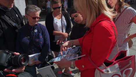 Dolly-Nahaufnahme-Einer-Reiseleiterin,-Die-Touristen-Einen-Stadtplan-Von-Venedig-Zeigt-Und-Die-Tour-An-Heißen-Sommertagen-Erklärt