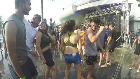 Beautiful-girls-of-India-enjoying-an-outdoor-pool-party-by-dancing-and-grooving-to-the-music-with-their-friends-as-water-splashes-by