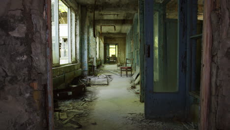Creepy-abandoned-corridor-of-Pripyat-commercial-building,-zoom-out-view