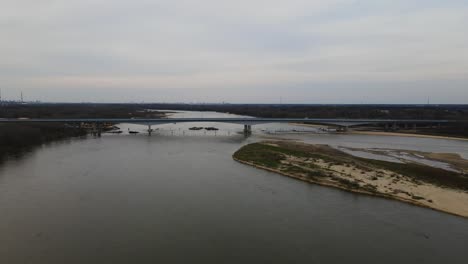 Aerial-view-over-Vistula-River-showing-bridge-construction-with-crossing-cars-during-cloudy-day-in-dusk