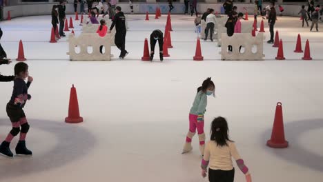 In-Einem-Einkaufszentrum-In-Hong-Kong-Sieht-Man-Menschen-Jeden-Alters-Beim-Eislaufen-In-Der-Halle