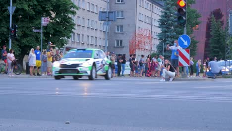 Inicio-Festivo-Del-Trofeo-De-Rally-Europeo-Fia-2021-Y-Desfile-De-Autos-En-Las-Calles-De-Liepaja,-Autos-De-Rally-Que-Pasan-A-Los-Espectadores,-Tiro-De-Seguimiento-De-ángulo-Bajo