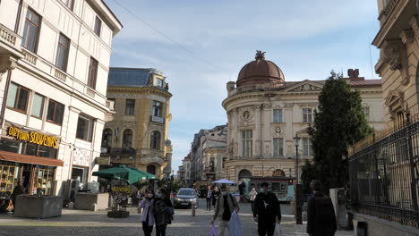 People-In-Masks-Walking-In-The-Street-In-Old-Town,-Bucharest,-Romania-During-Pandemic-With-Government-Building-In-Background