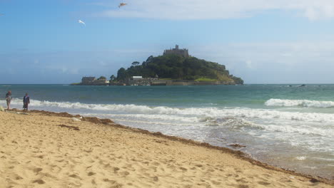 Monte-St-Michaels-Con-Gente-Caminando-En-La-Playa-En-Un-Hermoso-Día-De-Verano,-Plano-General