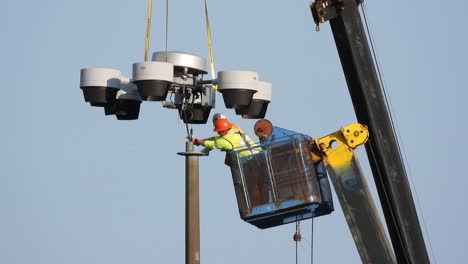 Männer-Bei-Der-Arbeit-In-Einem-Eimerlift,-Der-Das-Kabel-Eines-Industriellen-Autobahnlaternenpfostens-Mit-Beschädigten-Glühbirnen-Aufgrund-Eines-Unfalls-Durchtrennt