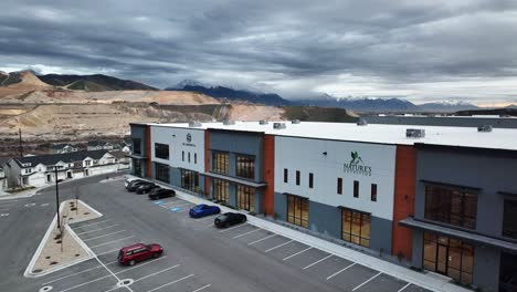 Aerial-View-of-Warehouses-and-Beautiful-Background-View-at-Bringhurst-Station-in-Bluffdale-Utah,-Orbit-Movement