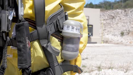 Hombre-Con-Traje-Amarillo-De-Materiales-Peligrosos-Que-Aprieta-Las-Herramientas-De-Forma-Segura-Antes-De-Entrar-En-La-Zona-Contaminada,-Primer-Plano