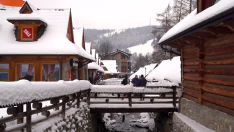 Gente-De-Pie-En-Un-Pequeño-Puente-Tomando-Fotos-En-Zakopane,-Polonia-En-Invierno