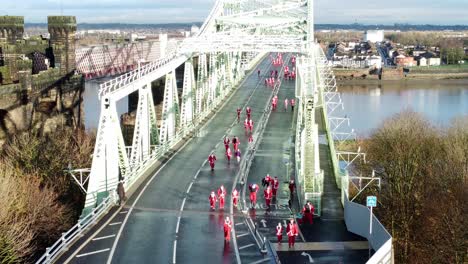 Charity-Santa-dash-fun-run-over-Runcorn-Silver-Jubilee-bridge-Aerial-view-slow-rising