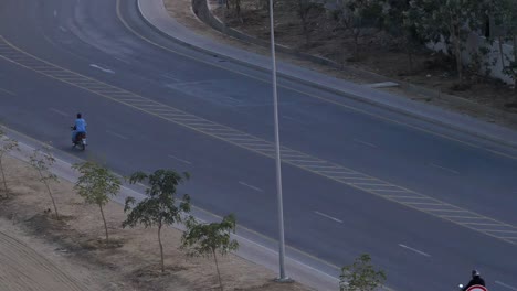 Traffic-Going-Past-Road-In-Late-Afternoon-In-Bahria-Town-In-Karachi,-Pakistan