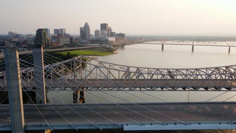 Aerial-drone-view-of-traffic-on-bridges-in-Louisville,-sunset-in-Kentucky,-USA