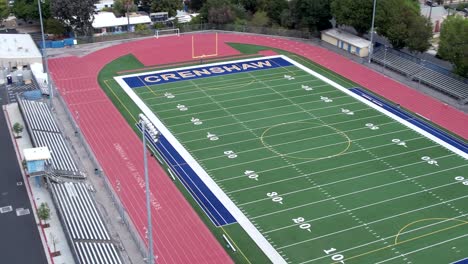 Crenshaw-high-football-field,-track-around-empty-field,-aerial-circling