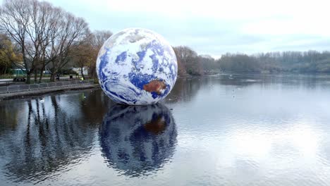 Luke-Jarram-floating-earth-exhibition-aerial-view-at-Pennington-flash-park-lake-push-in-slow-low