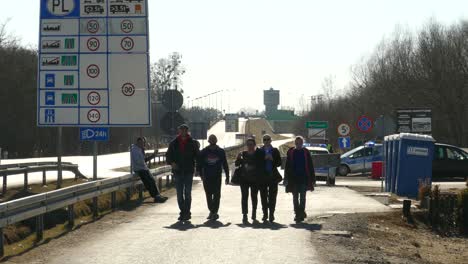 A-small-group-of-young-people-walks-along-a-highway-near-the-Polish-Ukraine-border-checkpoint