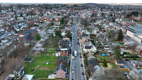 High-aerial-tracking-shot-of-white-truck-driving-through-American-city