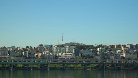 N-Seoul-Tower,-officially-the-YTN-Seoul-Tower-and-commonly-known-as-Namsan-Tower-or-Seoul-Tower-over-blue-sky-from-Han-river