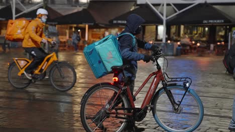 El-Ciclista-De-Deliveroo-Se-Sube-A-Su-Bicicleta-Eléctrica-Y-Recorre-La-Calle-Del-Centro-De-La-Ciudad-Para-Entregar-Pedidos-A-Clientes-Y-Clientes---Siguiendo-La-Foto-Del-Mensajero