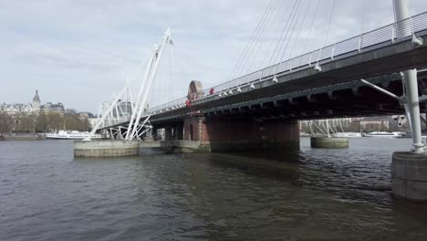 Maintenance-Worker-Hanging-Over-Side-Of-Golden-Jubilee-Bridge-On-River-Thames-In-London
