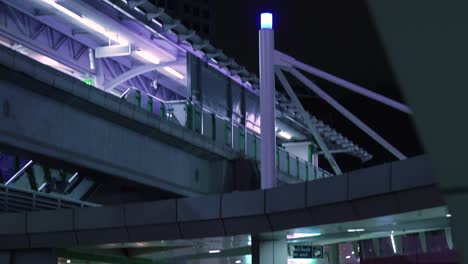 Shady-Gritty-Bangkok-at-Night,-BTS-Skytrain-Station-in-Bangkok-late-at-Night-with-colorful-Lights,-Bangkok-Concrete-Jungle